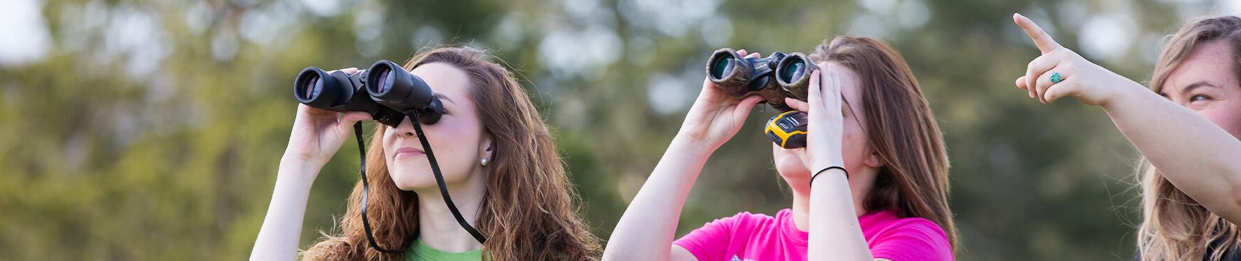 students observing nature through binoculars